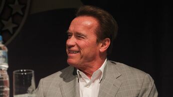 Arnold Schwarzenegger lachend auf einer Pressekonferenz in Rio.