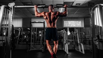 Back,View,Of,Muscular,Man,Doing,Pull,Up,On,Horizontal