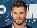 Chris Hemsworth trägt ein Jacket und ein offenes Hemd bei einer Präsentation eines Films.