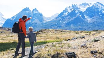Ein Vater wandert mit seinem Sohn im Gebirge. 