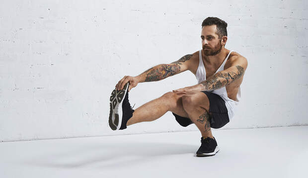 Einigen Athleten fällt der Pistol Squat leichter, wenn Sie den ausgestreckten Fuß mit der gleichseitigen Hand umfassen.