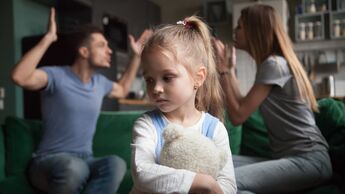 Eltern streiten sich und im Vordergrund sitzt ihr Kind