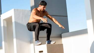 Mann springt für explosiven Boxjump auf eine Holzbox