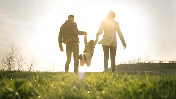 Mutter und Vater spielen mit ihrem kleinen Kind "Engelchen flieg"