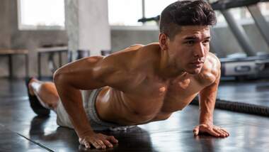 Starkes Fitnessmodel bei Push-ups im Gym