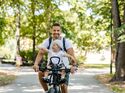 Vater fährt mit seinem Kind im Kindersitz Fahrrad