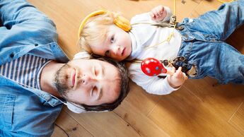 Vater und Sohn hören über Kopfhörer Podcasts