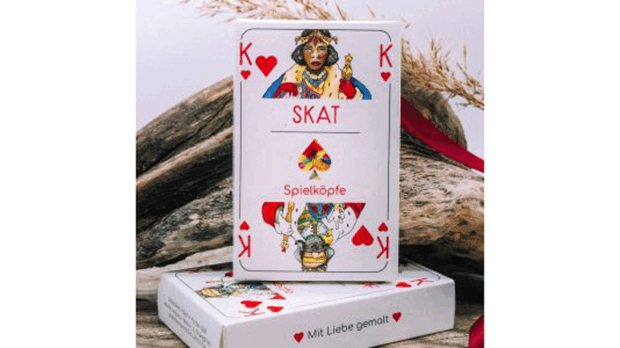 Zu sehen ist ein Kartenspiel, das eine dunkelhäutige Königin und einen hellhäutigen König zeigt.